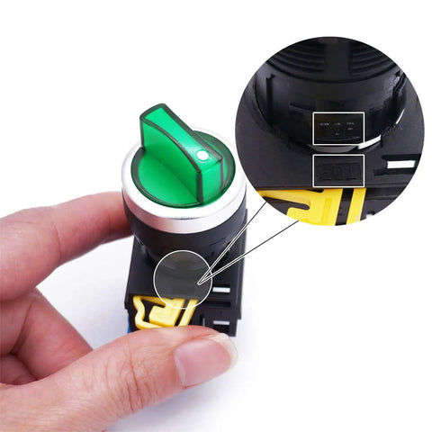 Close-up of a 22mm SPST 1NO two position maintained latching rotary selector switch with green LED indicator held in hand.