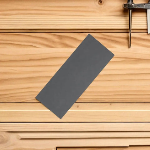 Grab A Pro Level 21pcs Emery Sandpaper Sheet Set For Wet Or Dry Grit Sanding On Metal And Wood Surfaces To Get That Smooth Polished Finish Fast And Easy Like A Boss, grey emery sheet on wood surface.