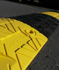 Eco XPT Speed Bump Kit With Cable Channel For Private Roads showing closeup of black and yellow modular sections on asphalt surface