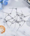 36 Pack 90 Degree V Shaped Torsion Springs, Stainless Steel, 0.5mm Wire Diameter, 5mm Outer Diameter, scattered on surface