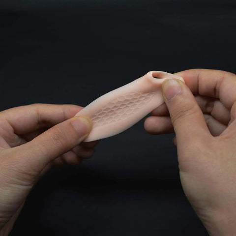 Close-up of hands holding Pinky Toe Protector And Bunion Corrector Gel Separator Cushion Sleeve showing texture, part of set of 10.