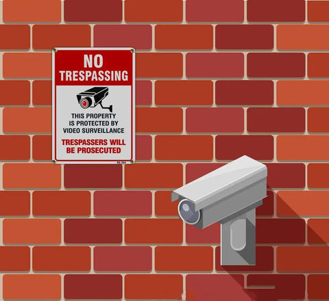 4-Pack No Trespassing Signs Outdoor For Private Property Made From Aluminum 10x14 Inches With UV Ink Print on brick wall with CCTV camera