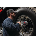 Pro Level One Inch Drive Air Impact Wrench being used by a mechanic on a truck tire for garage tasks.