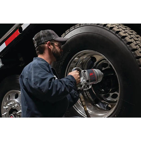 Pro Level One Inch Drive Air Impact Wrench being used by a mechanic on a truck tire for garage tasks.