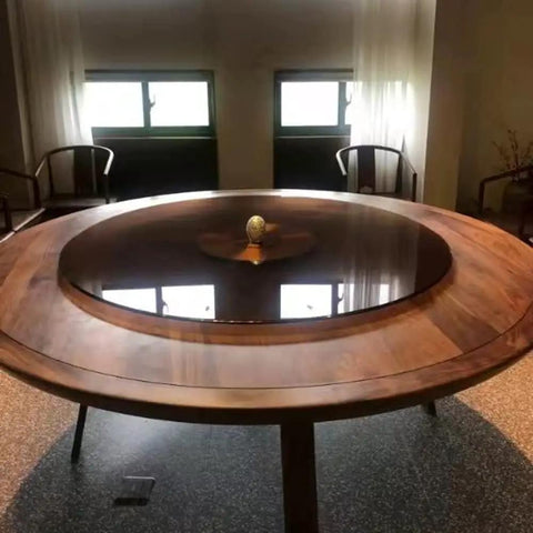 Black Tempered Glass Lazy Susan Turntable Serving Tray, 28 Inch Round Base with Heavy Duty Swivel Mechanism on a dining table.