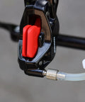 Close-up of the SRAM Brake Bleed Kit with Code Guide Level and DOT 5.1 fluid attached to a mountain bike brake component.