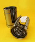 Open Linear Motion Bushing Bearing 12x21x30mm Two-Pack LM12UU-OP with rugged steel housing on yellow background