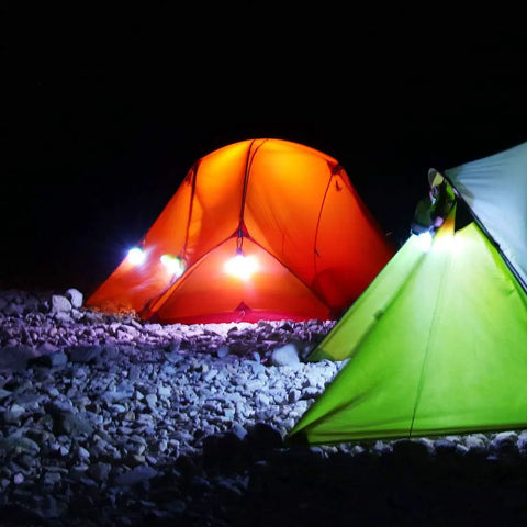 Night camping scene with two tents illuminated by Three Pack Portable LED Camping Lights With Three Modes High Low And Strobe Lightweight ABS Bulbs