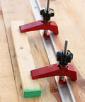 Rock Solid Aluminum T Track Hold Down Clamps For Woodworking And Metalworking Projects Plus Quick Slide In T Slot Press Clamps securing a wooden workpiece.