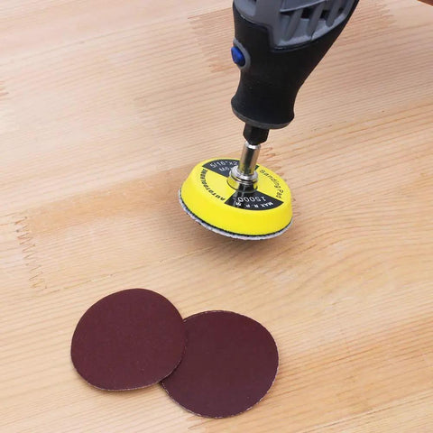 100 Pack 2 Inch Sanding Discs Kit With Polishing Pad Plate, Assorted Grits 40 Through 400, on wood surface with rotary tool.