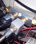 Close-up of two way pneumatic manifold air distribution block with G1/2 inlet ports and G1/4 outlet ports, installed in system.