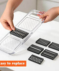 Front view of clear plastic mandoline slicer with stainless steel blades and safety hand guard