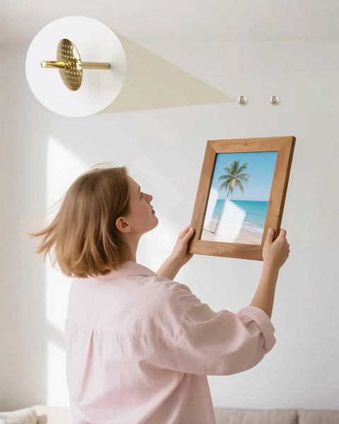 Person hanging a framed beach photo using Top Tier 80 Piece Picture Hanging Kit Featuring Assorted Bulletproof Metal Hooks And Heavy Duty Nails For Stress Free Wall Art Displays Supporting Up To 60 Pounds For Quick Do It Yourself Home Makeovers.