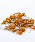 Massive 480 Piece Multilayer Ceramic Capacitor Kit With 24 Values From 10pF To 10uF scattered capacitors on white surface
