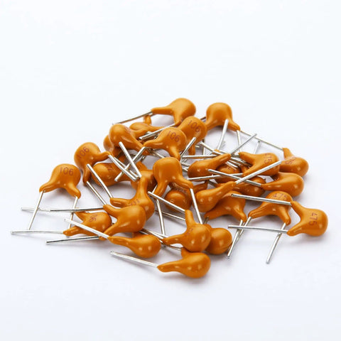 Massive 480 Piece Multilayer Ceramic Capacitor Kit With 24 Values From 10pF To 10uF scattered capacitors on white surface