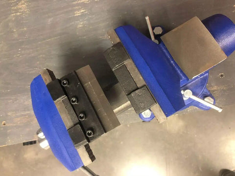 4 Inch Vise Mount Press Brake Bender Attachment for Sheet Metal Cross Slide, shown clamped in a blue vise, top view.