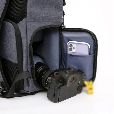 Open pocket of Waterproof DSLR Camera Backpack With Large Capacity And Anti Theft Design Reflector Stripe Detachable Tripod Strap Water Resistant Fabric Stain Resistant Rubber Base Comfortable Carry System For Photographers On The Go showing camera and phone inside.