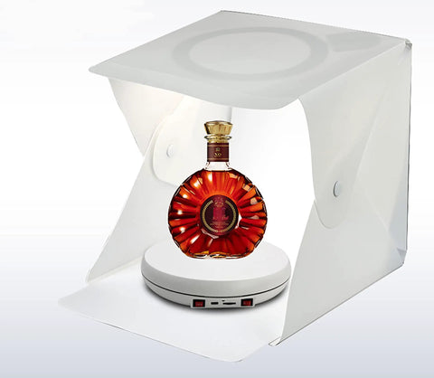 Rotating Display Stand With 10 Inch LED Light Turntable Base Black Spinning Platform showcasing a bottle in white light box