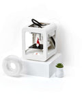 Beginner Friendly 3D Printer For Kids With Easy Setup And Safe Design shown with filament and a small plant