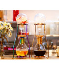 Craft Hella Smooth Cold Brew Coffee And Iced Tea With This No Sweat Dripper Featuring Adjustable Water Flow Stainless Steel Filter And Spacious Glass Carafe For Daily Sipping, showcasing two stylish drippers.