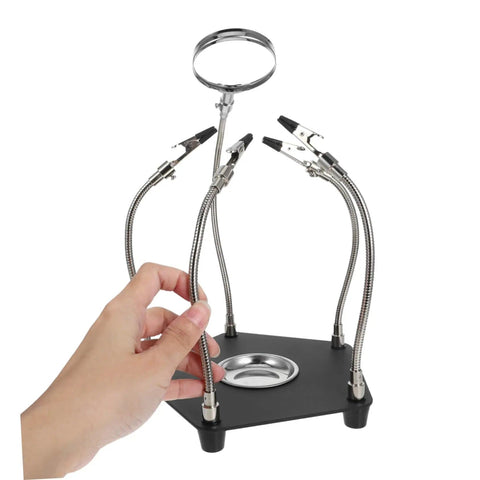 Hand holding Magnetic Third Hand Soldering Aid With Built In Magnifier for craft and PCB work, pro grade stainless steel tool.