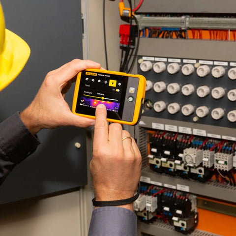 Technician using PTi120 Pocket Thermal Imager For Quick Infrared Inspections And Temperature Scans On The Go on electrical panel