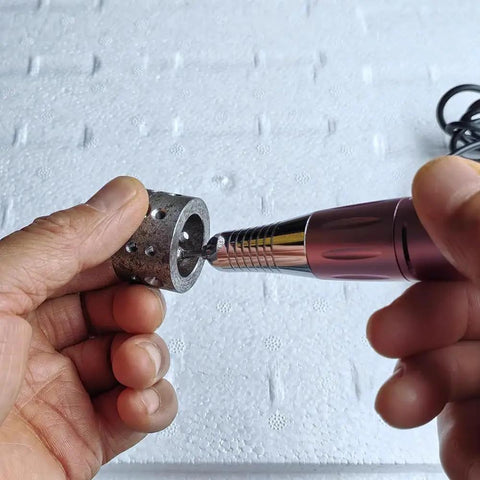 User holding Ultra Mini Electric Micro Hole Internal Chamfering Machine Deburring Tool with Diamond Grinding Head on cylindrical workpiece.