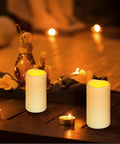 Waterproof Flameless LED Pillar Candles With Remote Timer Battery Operated Pack Of 3 in outdoor setting on wooden table.