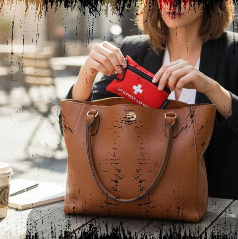 Lightning X Mini First Aid Kit red, 20-piece emergency kit with carabiner, placed into a brown leather tote bag