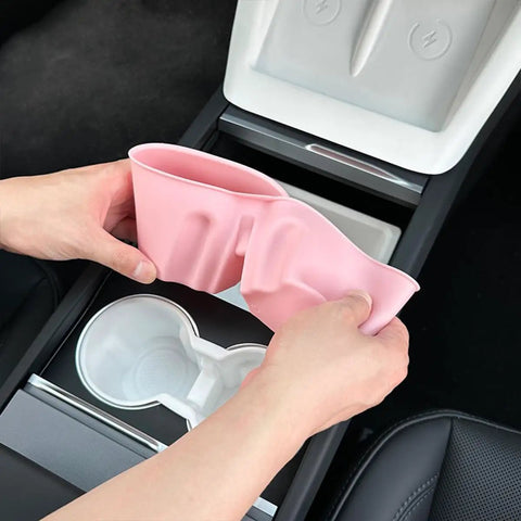 Person holding a pink Slick Drop In Premium Soft Silicone Cup Holder Insert For Tesla Model 3 Highland 2024 And Up.