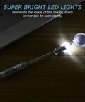 LED Lighted Stainless Steel Mouth Mirror For Teeth Inspection And Plaque Removal with illuminated head on wooden surface