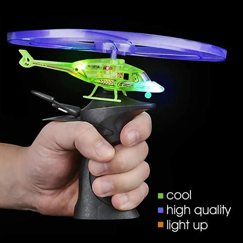 Person holding Light Up Flying Helicopters Set Of 2 With LED Lights And Handheld Launcher, showing glowing features.