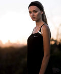 Person wearing a black tank top at sunset, highlighting Dope Front Bike Light With USB Rechargeable Battery, Clip On.
