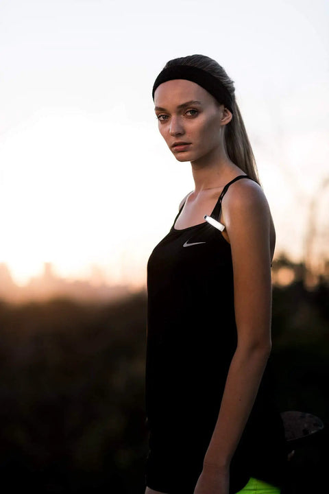 Person wearing a black tank top at sunset, highlighting Dope Front Bike Light With USB Rechargeable Battery, Clip On.