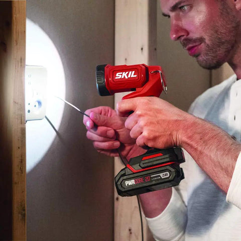 Man using LED spotlight from 4 Tool Power Kit With 20V Cordless Drill Driver Impact Driver Reciprocating Saw And LED Spotlight Includes Two 2Ah Batteries And Charger For Home DIY Projects