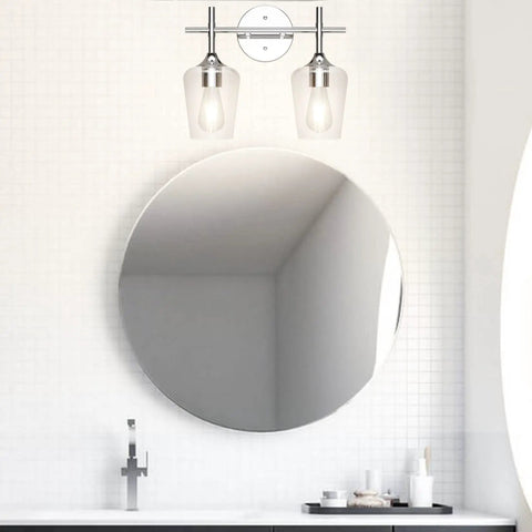 Chrome Two Light Bathroom Fixture With Clear Glass Wall Mount Sconce over round mirror in modern bathroom