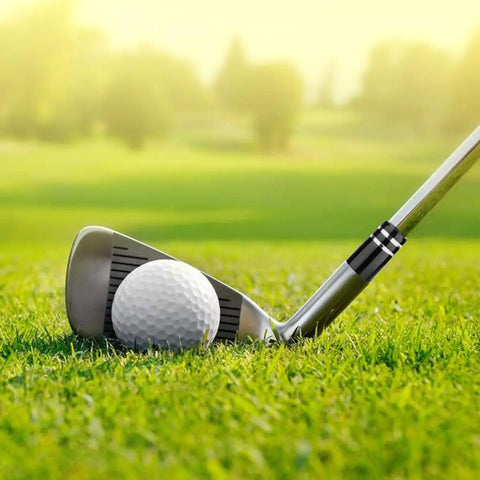 Close-up of a golf club with Premium.370 Inch Iron Ferrules For Taper Tip Golf Shafts, 12 Pack With Black And Double Chrome Ring on grass