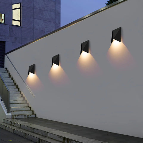 Four 10W 3000K Waterproof IP65 Indoor Outdoor Wall Sconce LED Light Fixture illuminating a modern exterior wall at dusk.