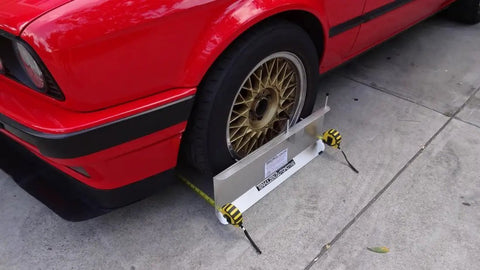Heavy Duty 2 Wheel Alignment Tool For Camber Caster And Toe With Knockout Precision Wheel Standoffs beside red car wheel.