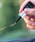 Close-up of No Fuss Windshield Crack Repair Kit for Chips and Small Cracks being applied on automotive glass with nano resin.