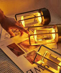 Portable Metal Table Lamp Cordless Rechargeable LED Light With 3 Color Infinitely Dimming Battery Powered Small Desk Lamp For Indoor Outdoor Use Ideal For Home Bar Cafe Camping In Sleek Gold illuminating a magazine.