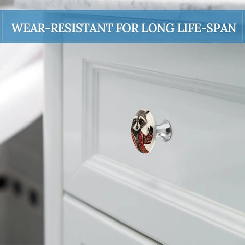 2 Pack Super Slick Red Raccoon Painted Drawer Knobs With Hella Tough 1.1 Inch Stainless Steel Base mounted on white cabinet.