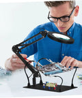 Man using adjustable soldering arm with magnifying glass and lamp clamp handy multi tool for welding electronics workstation