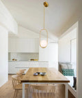 Gold Globe Pendant Light Fixture With Adjustable Hanging Length, Modern Mid Century Chandelier in a dining room setting.