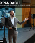 Man using UHF Wireless Mic System For Teaching And Events With Dual Lavalier And Headset Mics on stage with speakers