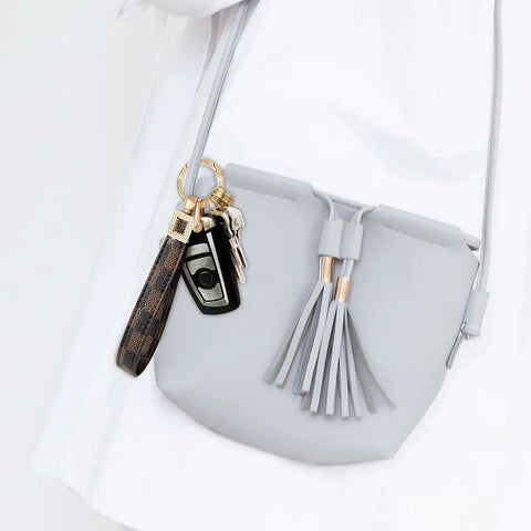 Dope And Totally Legit Premium Leather Wristlet Keychain Featuring Sparkling Crystal Diamonds And Classy Craft Pearls for keys attached to a gray purse.