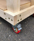 Rock Hard Five Inch Red Polyurethane Swivel Castors Four Pack Furniture Wheels with locking brake on wooden cart.
