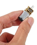 Hand holding Tiny All-Metal 12V 30RPM Gear Motor With Gearbox For DIY RC Toys And Smart Cars, N20 Reduction, Mini Micro Gearhead