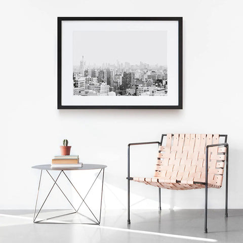 Peel And Stick Molding And Wall Trim Set For DIY Home Decor On Cabinets Doors Mirrors And Frames Self Adhesive No Mess Easy Install Non Toxic 16.4 Ft Long By 0.8 In Wide in a minimalistic room with a cityscape frame, woven chair, and table.