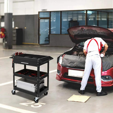 Beefy Three Tier Rolling Tool Cart With Drawer On Wheels, 330 LBS Capacity Heavy Duty Utility Cart With Two Brakes, Industrial Steel Tool Organizer For Garage, Mechanic Shop, Warehouse And Repair Bay. Black steel 3-tier cart with drawer beside car repair bay